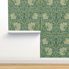 a green wallpaper with an intricate design on it's side and the corner of a room