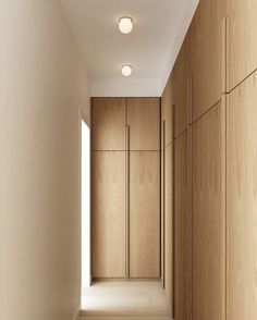 an empty hallway with wooden cabinets and lights