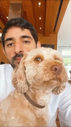 a man holding a dog in his arms and posing for a photo with it's owner