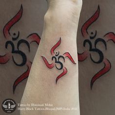 a person's arm with an omen symbol on it and two other symbols behind them