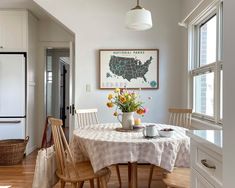 a dining room table with two chairs and a potted plant on top of it