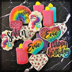 decorated cookies with happy birthday written on them in rainbow colors and unicorn - shaped frosting