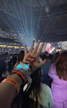 someone is holding their hand up in the air at a concert with lights on them