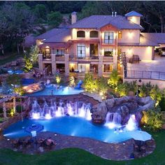 an aerial view of a large house with a pool and waterfall in the front yard