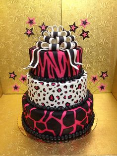 a three tiered cake decorated with zebra print and pink, black and white designs