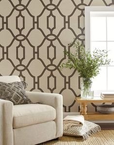 a living room scene with focus on the couch and wallpaper that has a trellis pattern