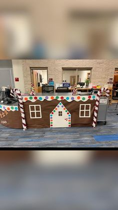 an office decorated for christmas with gingerbread houses and candy canes on the roof