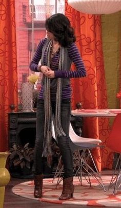 a woman standing in front of a table with chairs and a vase on top of it