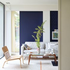 a living room with blue walls and white furniture