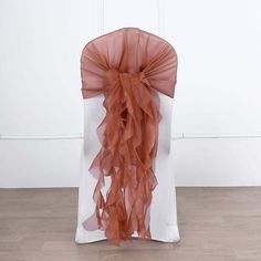 the back of a white chair with an orange sash draped over it's back