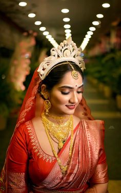 a woman in a red sari with a tiara and jewelry on her head