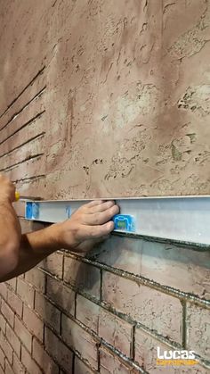 a man is working on a brick wall with a sawtoothing tool in his hand