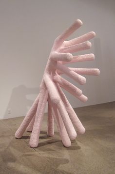 a pink sculpture sitting on top of a floor next to a white wall