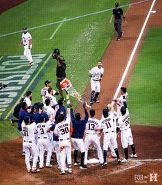 a group of baseball players standing on top of a field next to each other in front of a crowd