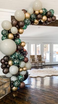 a large balloon arch in the middle of a kitchen with balloons hanging from it's ceiling