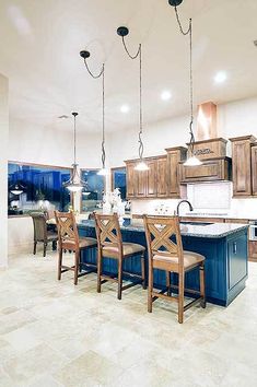 a large kitchen with wooden cabinets and blue island