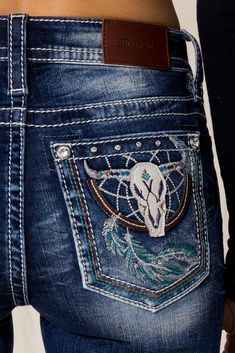 Mid rise dark wash bootcut detailed with hand sanding, embroidered dream catcher and long horn and a 5 pocket with rhinestone rivets. 73% Cotton, 24% Polyester, 3% Elastane Machine Wash Separately In Cold Water With Like Colors Front Rise: 9"; Back Rise: 14” Inseam: 34" Style No. M3923B-D1031 Bootcut Jeans With Designs, Embroidered Bootcut Jeans, Bedazzled Bootcut Jeans, Bootcut Jeans With Rhinestones, Bootcut Jeans With Pocket Design, Country Jeans, Y2k Grunge Outfits, July 4th Sale, Cowgirl Jeans