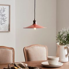 a wooden table topped with plates and cups