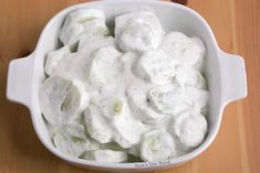 a white bowl filled with food on top of a wooden table