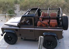 an off road vehicle parked on the side of the road next to some sand dunes