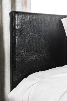 a black headboard with white sheets and pillows