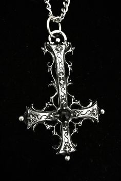 The Traumaturgist's Cross is a handcrafted piece made from fine pewter, containing 98% tin, featuring an intricate gothic inverted cross design that measures 7 cm in height. This pendant is adorned with a gemstone of your choice, allowing for personalization and enhancement of its significance. It comes with a choice of a stainless steel chain in either 18 or 24 inches, ensuring durability and hypoallergenic properties. The inverted cross is a powerful symbol often associated with the themes of Silver Ankh Gothic Necklace, Gothic Metal Cross Pendant Jewelry, Gothic Cross Metal Jewelry, Gothic Cross Pendant Jewelry, Gothic Metal Cross Jewelry, Vintage Cross Necklace With Antique Finish, Gothic Sterling Silver Crucifix Necklace, Gothic Cross Necklaces For Jewelry Making, Antique Crucifix Collectible Jewelry