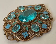 "Czech Czechoslovakia unmarked Paraiba blue rhinestone, blue, green enamel flower, filigree brooch  Excellent condition  size - 2 7/8\" x 2 3/8\"  1930-s.  00853 09/20/22" Ornate Blue Brooches For Wedding, Ornate Blue Wedding Brooches, Antique Blue Enamel Brooches, Art Deco Blue Brooches As Gifts, Art Deco Blue Brooches For Gifts, Diamanda Galas, Czech Jewelry, Antique Costume Jewelry, Rhinestone Tiara