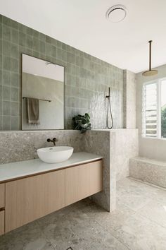 a bathroom with a sink, mirror and bathtub