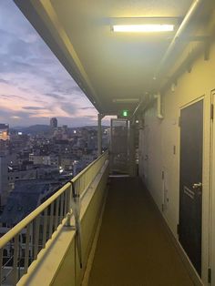 an empty hallway leading to the top of a building with lights on and buildings in the background