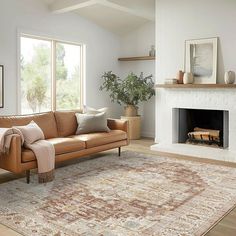 a living room filled with furniture and a fire place next to a large rug on top of a hard wood floor