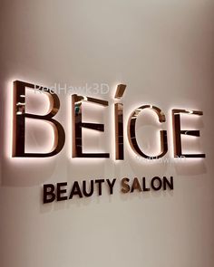 a sign that says belge beauty salon on the side of a wall with lights above it