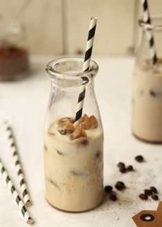 two glasses filled with milkshakes sitting on top of a table next to chocolate chips