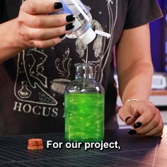 a person pouring green liquid into a bottle