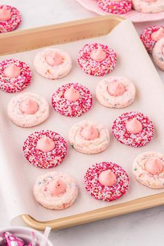 pink sprinkle covered donuts are on a baking sheet and ready to be baked