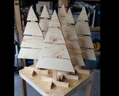 a wooden christmas tree sitting on top of a table in a room filled with tools