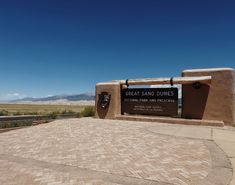 there is a sign that says great sand dunes in front of the entrance to the park