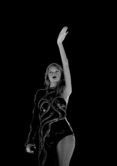 a woman in a black and white photo with her arms up