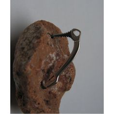 a rock with a pair of scissors hanging from it's side on a hook