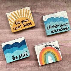 four painted wooden magnets with words on them