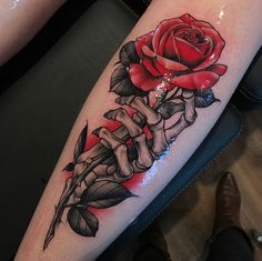 a rose and bones tattoo on the leg