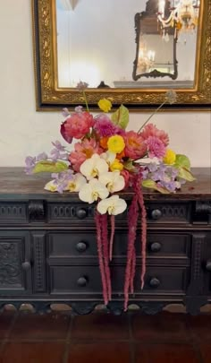 a vase filled with flowers sitting on top of a dresser