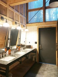 a bathroom with double sinks and mirrors in it's center wall, along with two lights on either side of the mirror