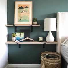 a bed room with a neatly made bed and a shelf on the wall above it