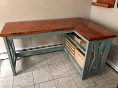 a wooden desk with drawers underneath it in a room that has tile flooring and white walls