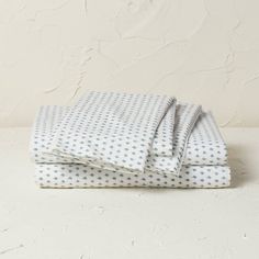 a white and blue polka dot sheet set on top of a table next to a wall