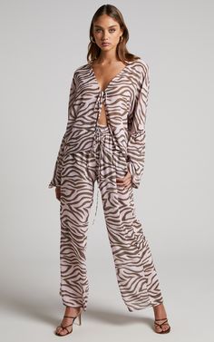 Go wild with the Aegir Pants! Featuring mid-high rise elastic waist with drawstrings,  straight legs, relaxed fit and a pink zebra print all over. They're easy, breezy and perfect casual days out, parties and beyond.Style it with the Aegir Blouse - Tie Front Drop Sleeve Blouse in Wild Zebra and chunky sandals for a relaxed vacay look. Or pop on heeled sandals and a shoulder bag for a party look!Product Details   Pull on style, no fasteningElasticated waistband with adjustable drawstringsMid-high Trendy Beach Pants With Drawstring, Trendy Drawstring Pants For The Beach, Casual Zebra Print Bottoms For Summer, Casual Zebra Print Summer Bottoms, Casual Tiger Print Bottoms For Summer, Casual Tiger Print Summer Bottoms, Summer Zebra Print Wide Leg Bottoms, Casual Summer Bottoms With Tiger Print, Casual Wide Leg Bottoms With Zebra Print