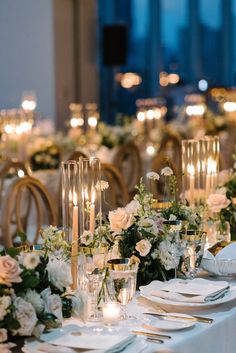 the table is set with white flowers and candles for an elegant wedding reception or special event