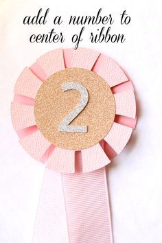 a pink ribbon with the number 2 on it and text that reads, add a number to center of ribbon