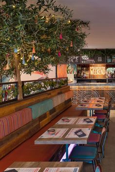 tables and chairs are lined up in a restaurant with colorful lights on the wall behind them