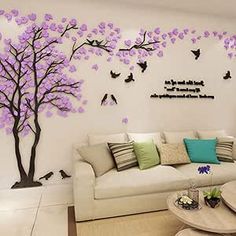 the living room is decorated in white and has purple tree decals on the wall